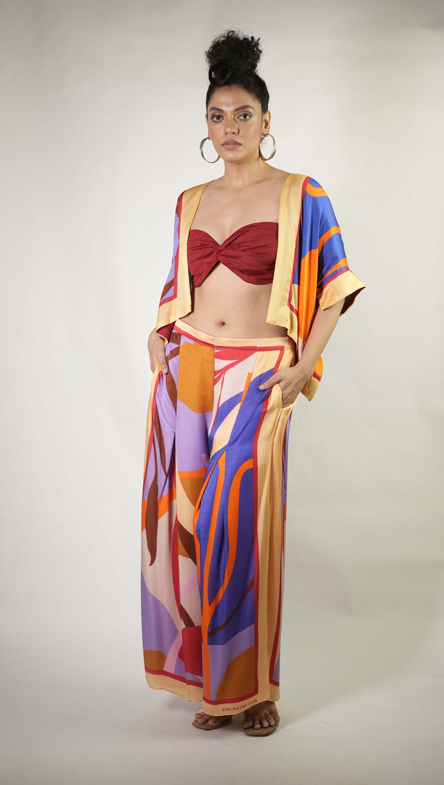 Bold graphic printed shrug and trousers teamed with bralette