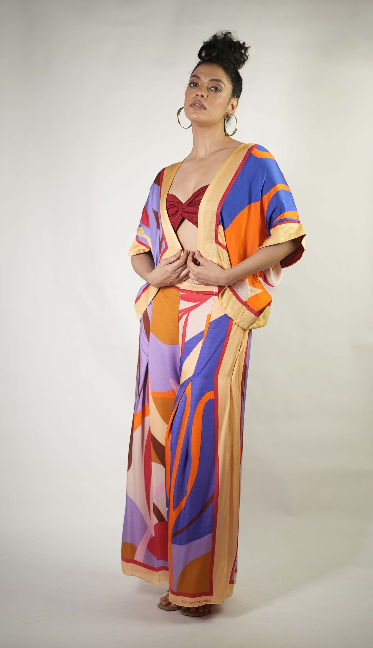 Bold graphic printed shrug and trousers teamed with bralette