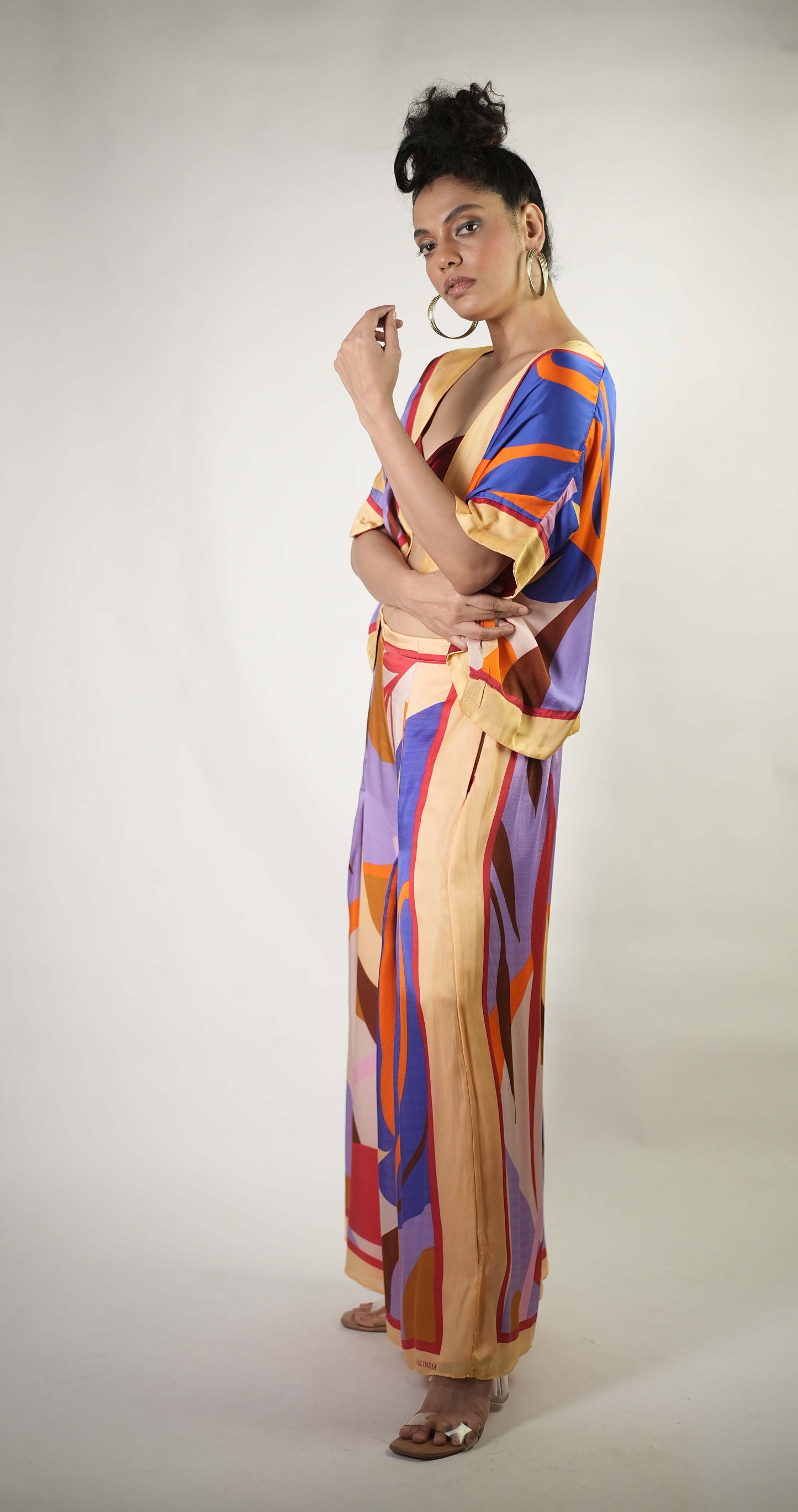 Bold graphic printed shrug and trousers teamed with bralette
