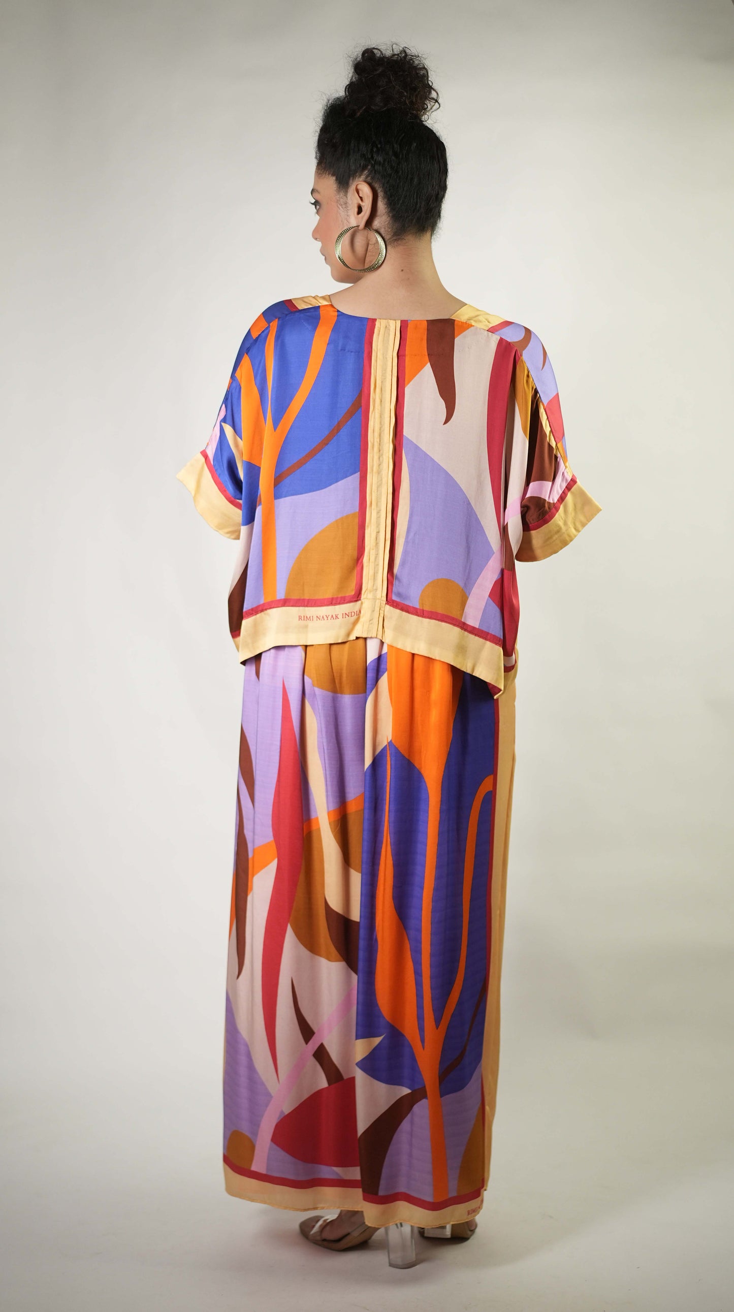 Bold graphic printed shrug and trousers teamed with bralette