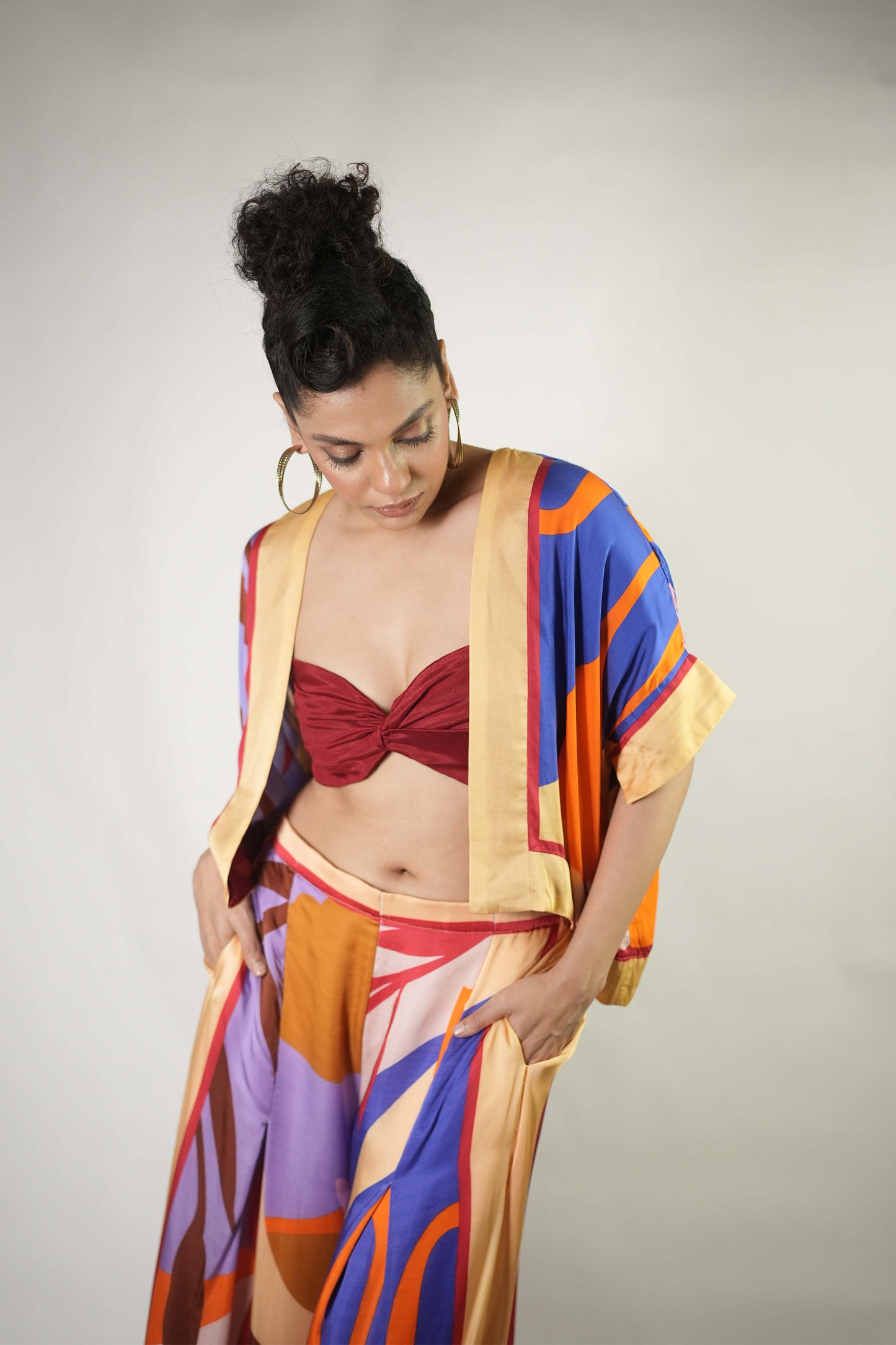 Bold graphic printed shrug and trousers teamed with bralette