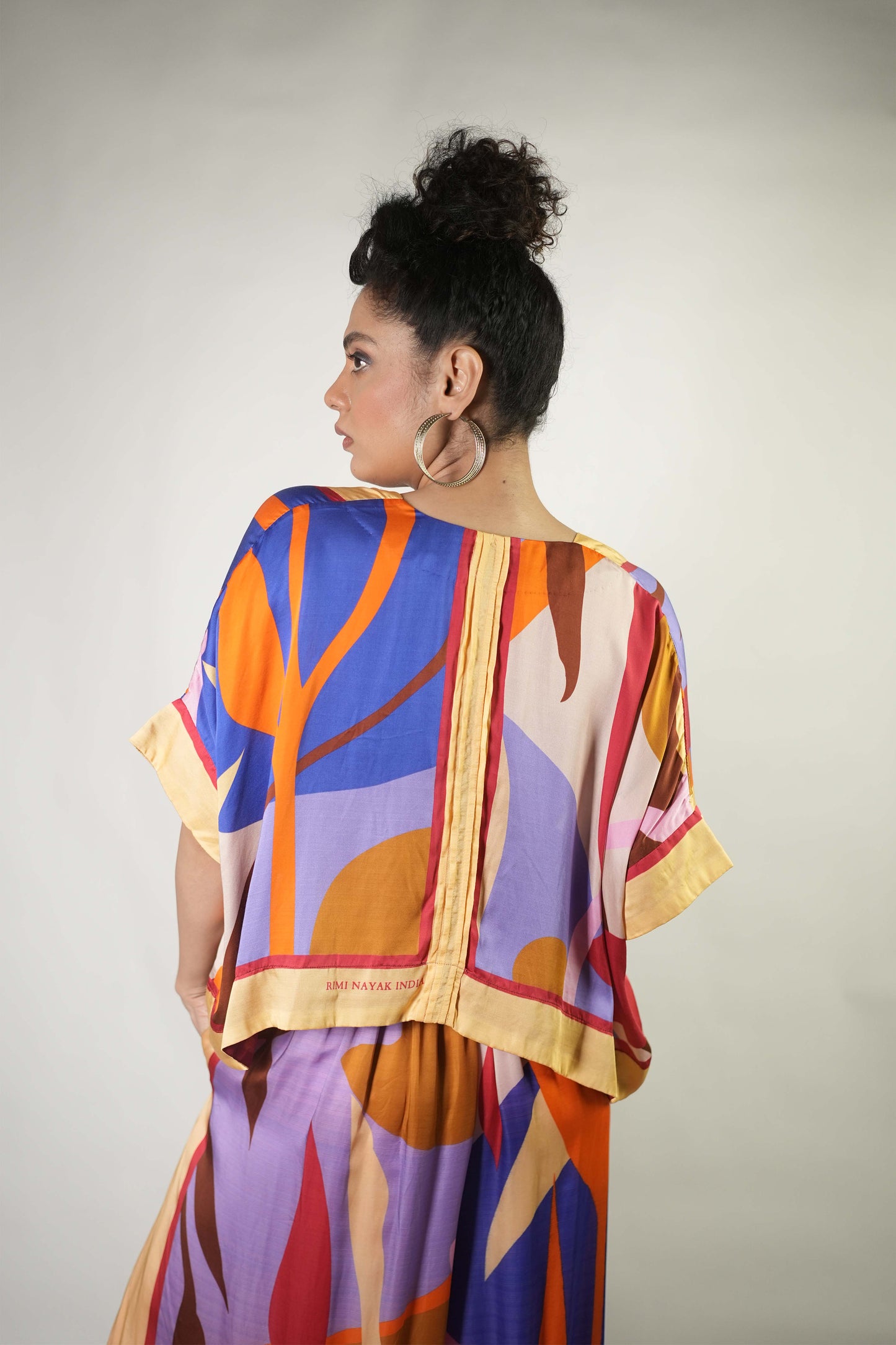 Bold graphic printed shrug and trousers teamed with bralette